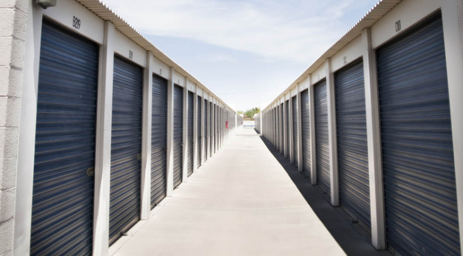A row of outdoor storage units with blue doors in a clean environment