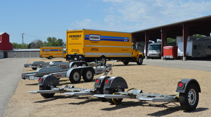 Outdoor parking area with moving trucks, RVs, and spare trailers