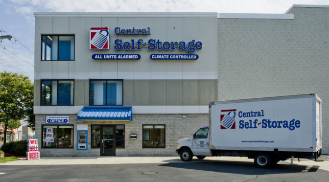 Exterior view of a Central Self Storage facility with a moving truck parked outside