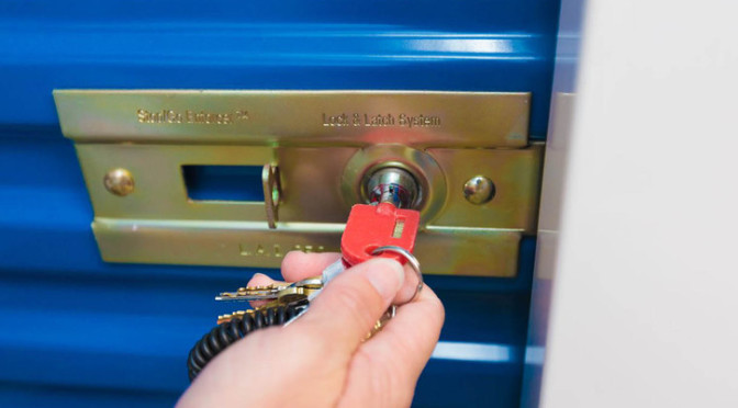 A person using a key to unlock a storage unit