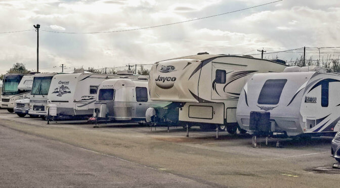 Outdoor parking area with RVs and trailers parked next to each other