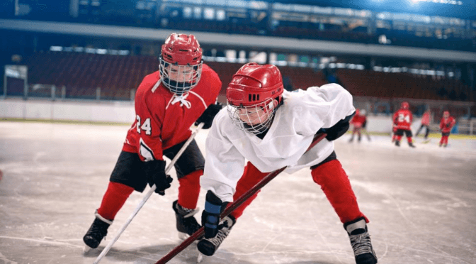Two youth hockey players fighting for the puck