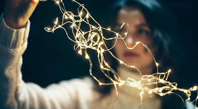 A woman holding a string of tangled lights