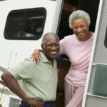 A couple in the door of their mobile home