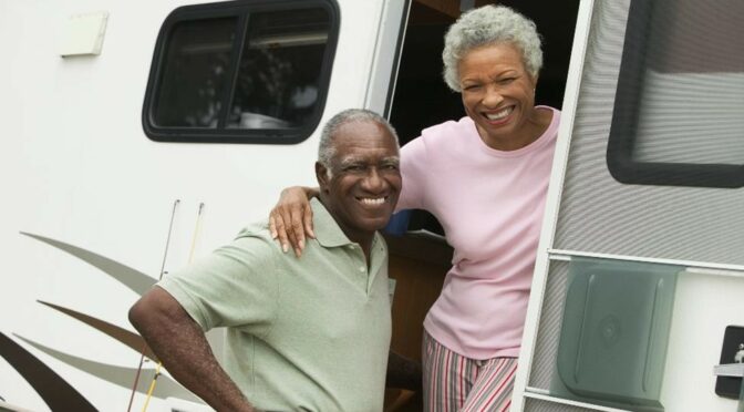 A couple in the door of their mobile home