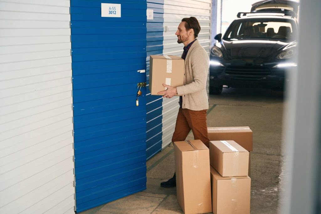 Man walks up to his drive-up storage unit next to his car.