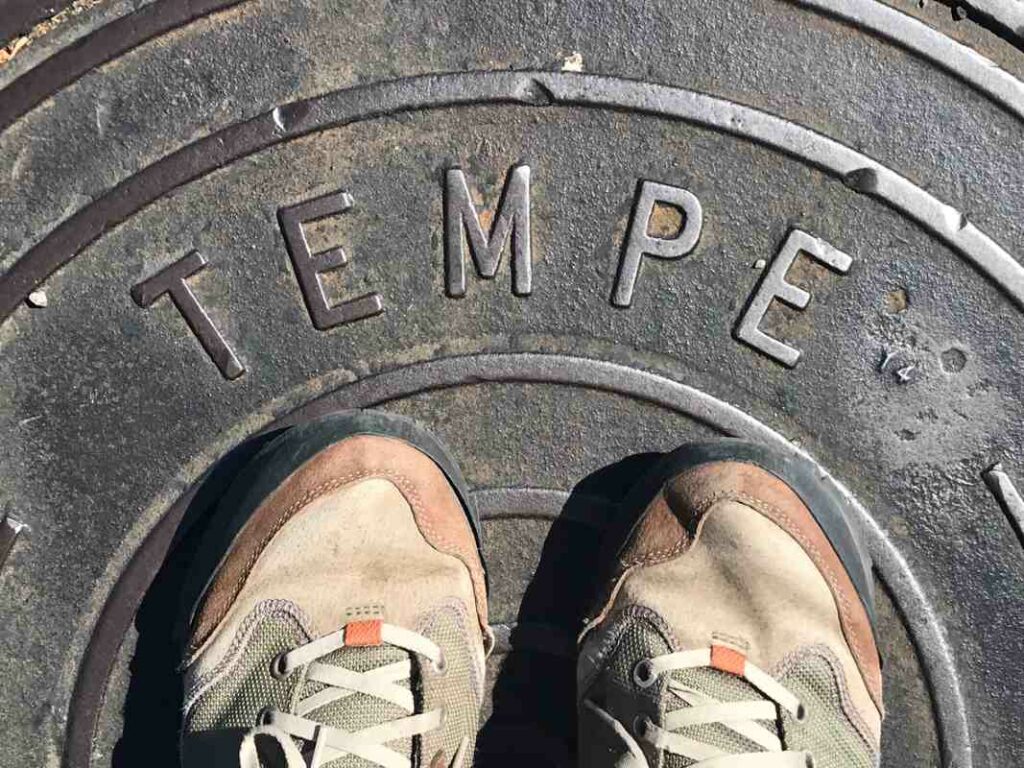 A person standing on a sign that reads "tempe"