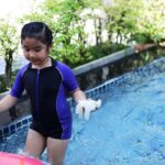 A young girl is playing in the swimming pool