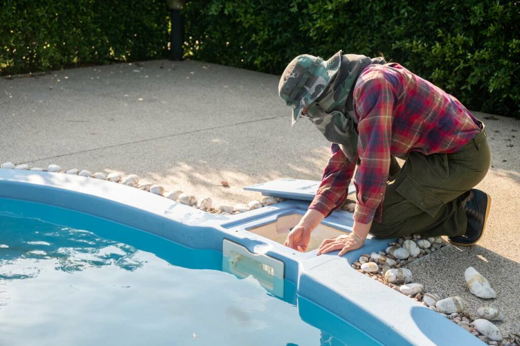 Technician checking a pool skimmer.