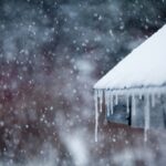 Icicles form on the gutter of a snow-covered roof.